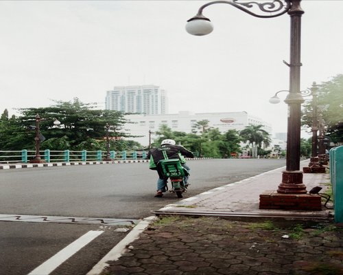 A commuter mindfully standing and balancing during a journey on the modern MRT line in Surabaya